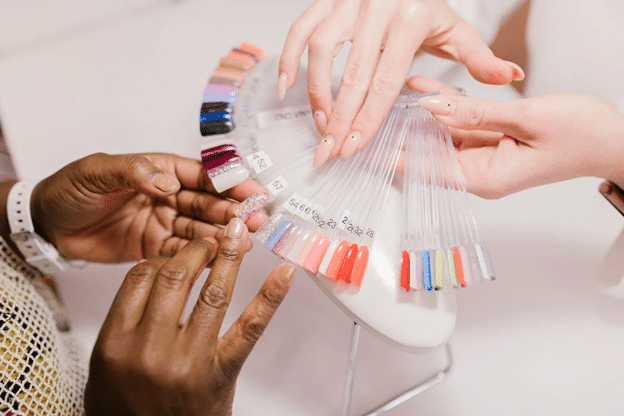 A customer picking colors from a nail color palette in the salon.